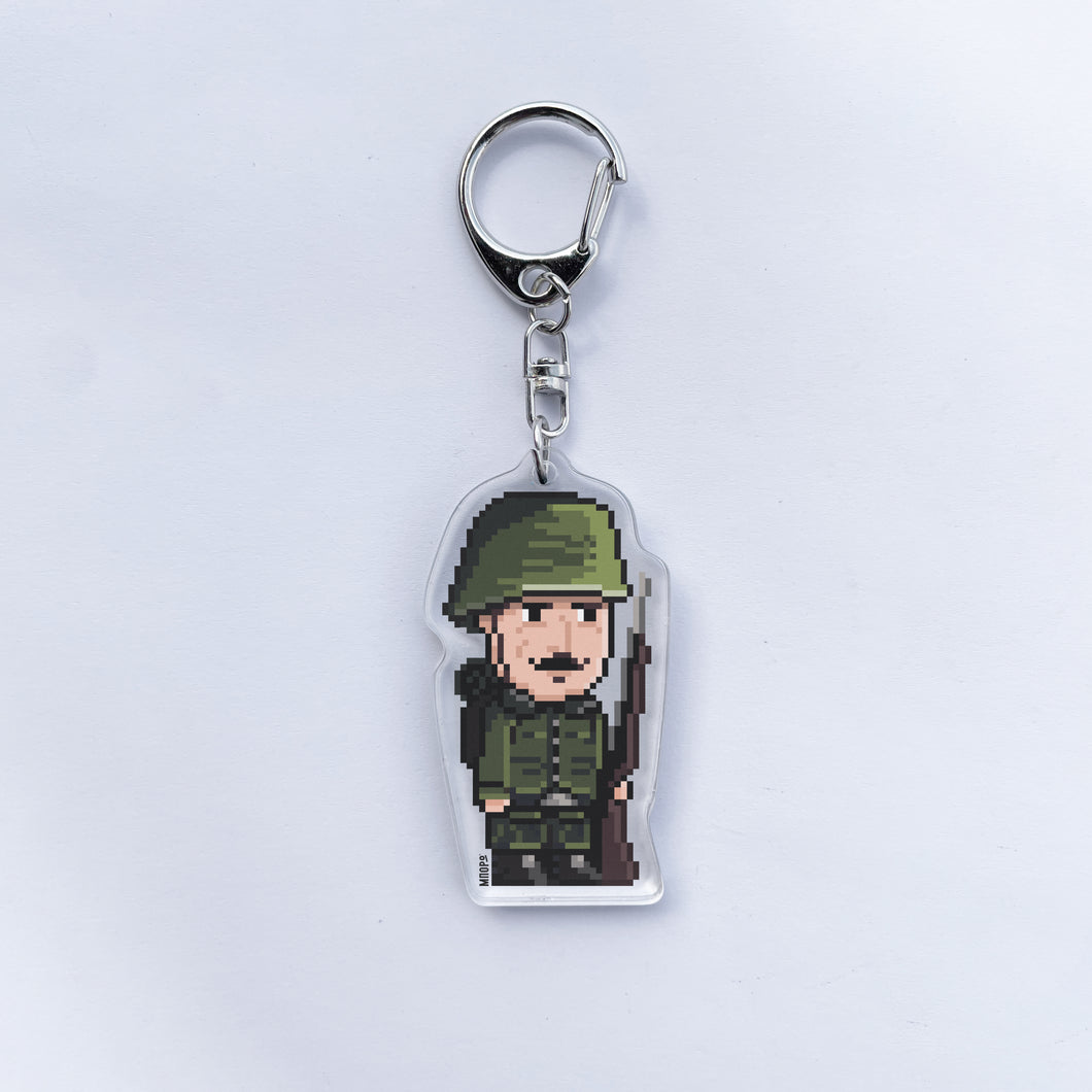 A picture of a keychain with a pixel art character of a greek soldier of 1940